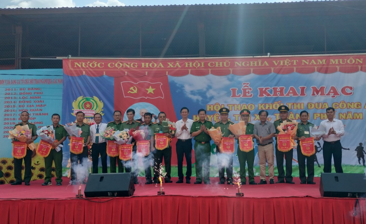 Các đồng chí lãnh đạo Công an tỉnh và huyện Bù Đăng tặng cờ lưu niệm cho các đoàn tham gia hội thao